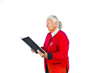smiling attractive elderly woman reading in a book and making a
