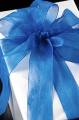 Blue gift bow on silver box, close-up