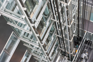 Looking down in  an open steel lift shaft in a modern buldin