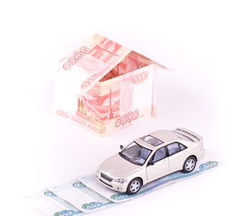 Model car in the house of banknotes isolated