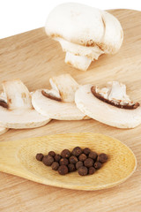 Fresh mushrooms with spoon of pepper