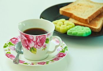 a cup of hot coffee, spoon and the delicious dessert
