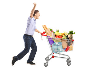 Euphoric man pushing a shopping cart full with food