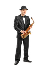 Full length portrait of a man in a suit holding a saxophone