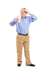 Full length portrait of a surprised senior looking at store rece