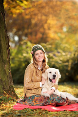 Young woman hugging a labrador retreiver dog out in the park