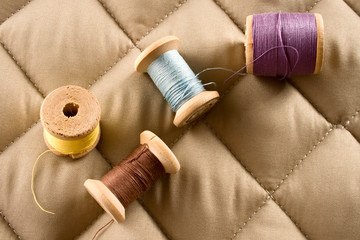 Thread bobbins on a beige fabric