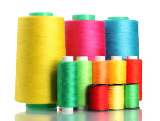 Many-coloured bobbins of thread isolated on white