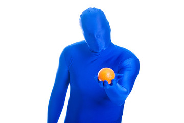 Faceless, anonymous blue man holding a fresh orange.