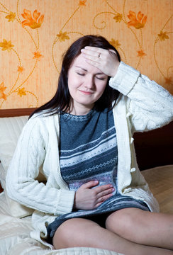 Woman with pain in her belly and head