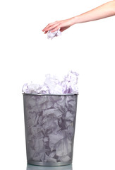 Metal trash bin from paper and hand isolated on white