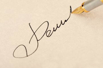 The signature close up and fountain pen. Old yellow paper