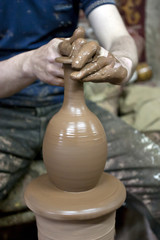 Hands of a potter, creating an earthen jar