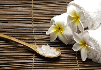 frangipani and salt in spoon and towel on stick straw mat