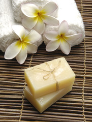 Obraz na płótnie Canvas natural handmade soap with frangipani flower with roller towel