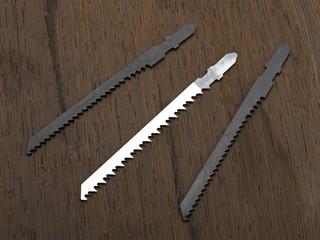 Metal and wood jigsaw blades on a wooden block