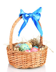 Colorful Easter eggs in the basket with a blue bow isolated