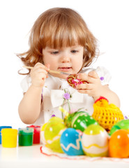 Fototapeta na wymiar Cute little girl painting Easter eggs