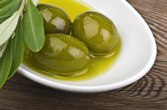 green olives and oil on the spoon