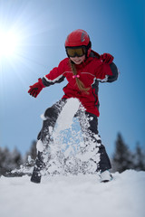 Young girl skier playing with snow