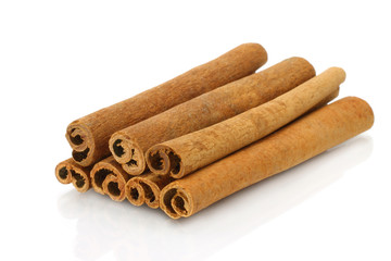 Heap of cinnamon sticks on white background