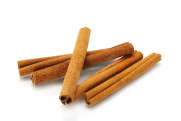 Heap of cinnamon sticks on white background