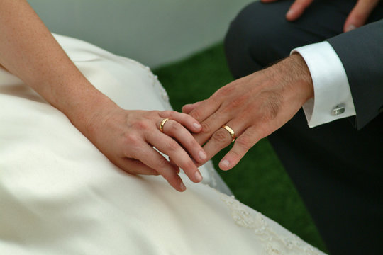 Mani di sposi con anelli