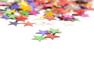 Christmas decoration of colored confetti stars against white bac