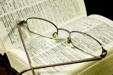 reading glasses on an open dictionary