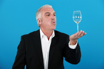 Man blowing a wine glass