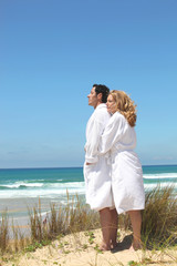 couple in robes on the beach