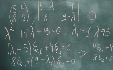 formulas written on green chalkboard