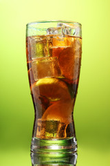 Iced tea with lemon and lime on green background