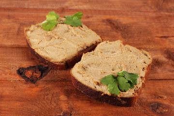 Fresh pate on bread on wooden table