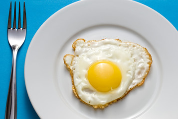 Fried egg on a plate with flatware