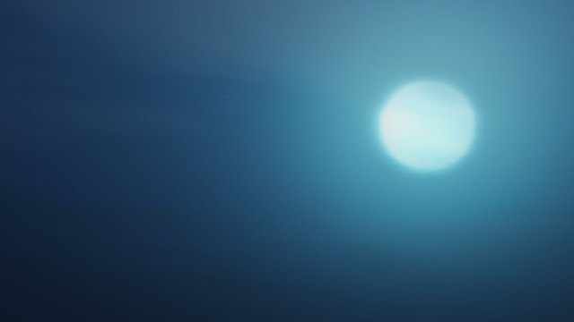 Peaceful time lapse Moon setting in a plain blue sky