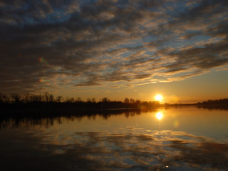 sunset with beautiful cloudy sky over lake