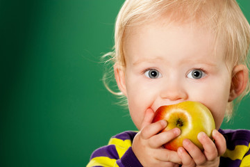 Fototapeta na wymiar Ребенок с яблоком на зеленом фоне