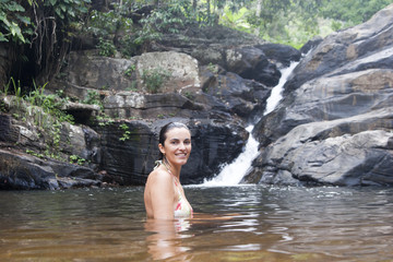 Frau badet am Wasserfall