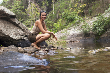 Frau in der Natur am Fluss schaut in die Kamera