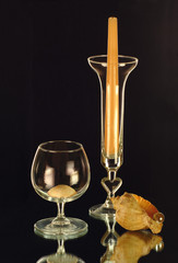 A candle, a wineglass and cockleshells