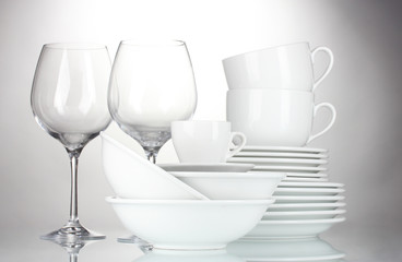 Fototapeta na wymiar empty bowls, plates, cups and glasses on grey background