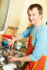 Housekeeper man with dish washing machine