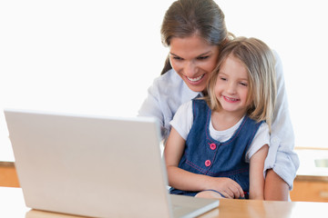 Mother and her daughter using a notebook