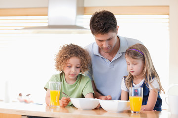 Obraz na płótnie Canvas Ojciec z dziećmi o śniadanie