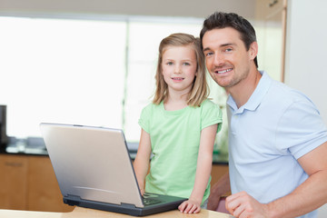 Father and daughter using laptop