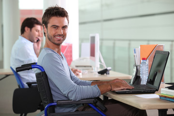 Fototapeta na wymiar Man in wheelchair on laptop