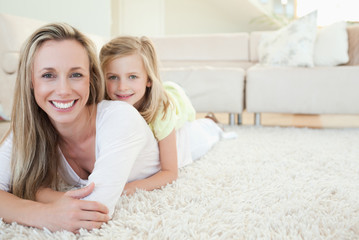 Mother and daughter lying on the floor
