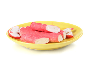 Crab sticks on yellow plate isolated on white