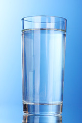 Glass of water on blue background